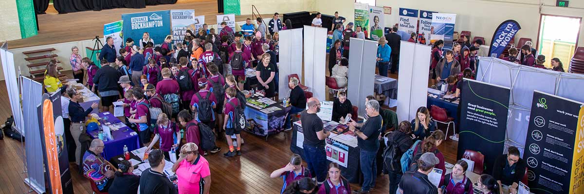 Rows of students and job-seekers speak to exhibitors at a careers expo event