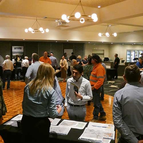 A man and walk talk at inside a room filled with stalls